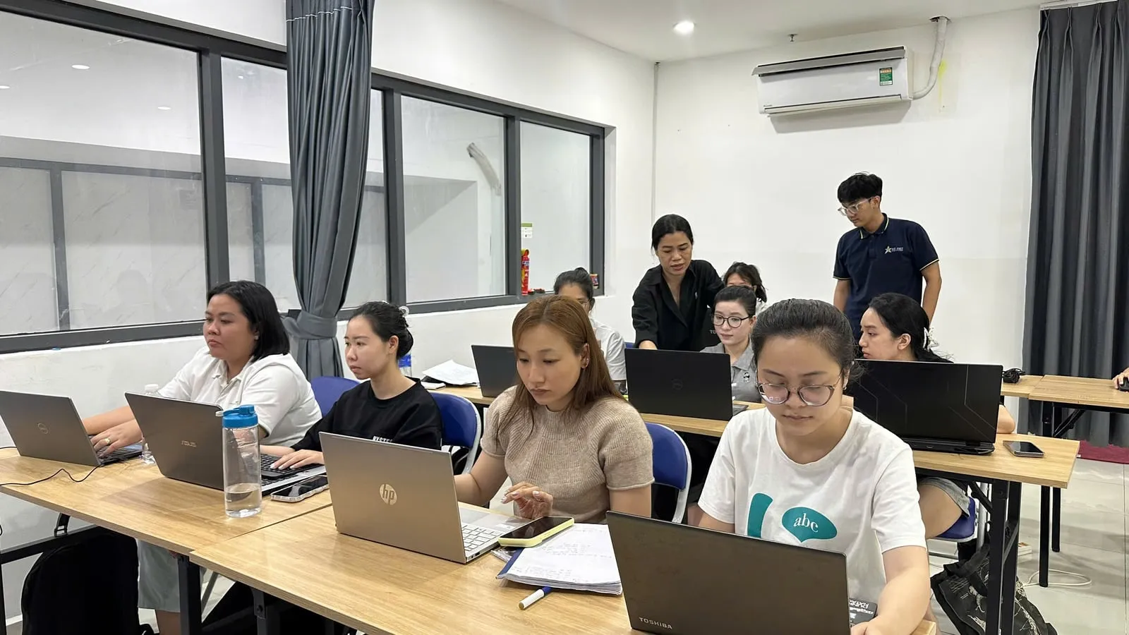Lớp học người lớn với hai giảng viên hỗ trợ