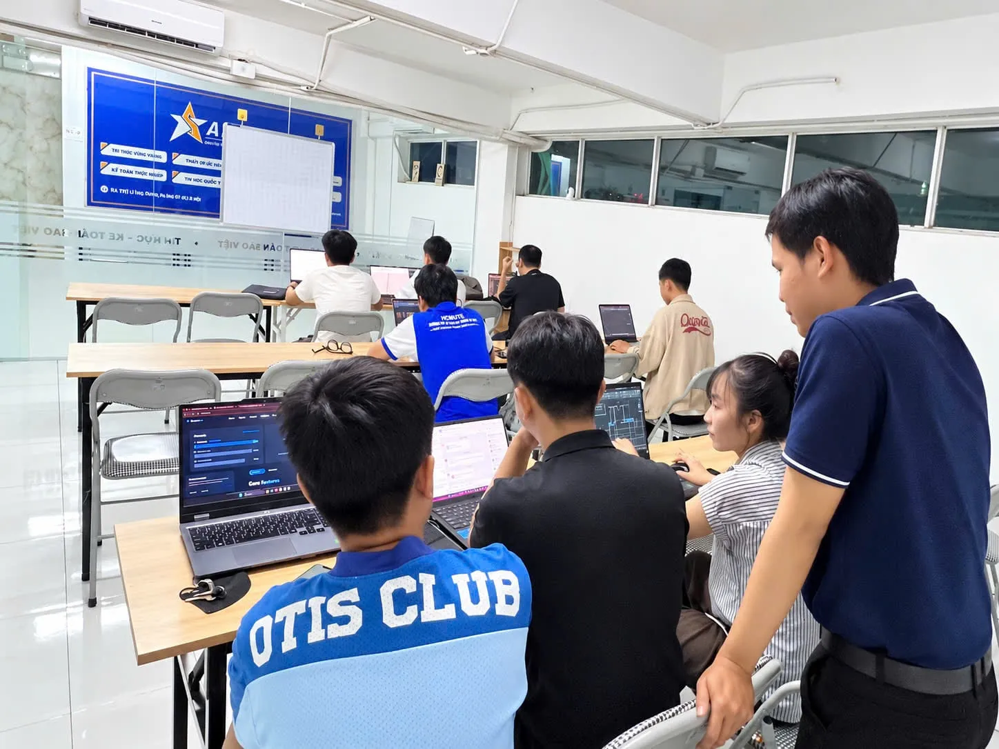 Giảng viên hỗ trợ học viên tại laptop