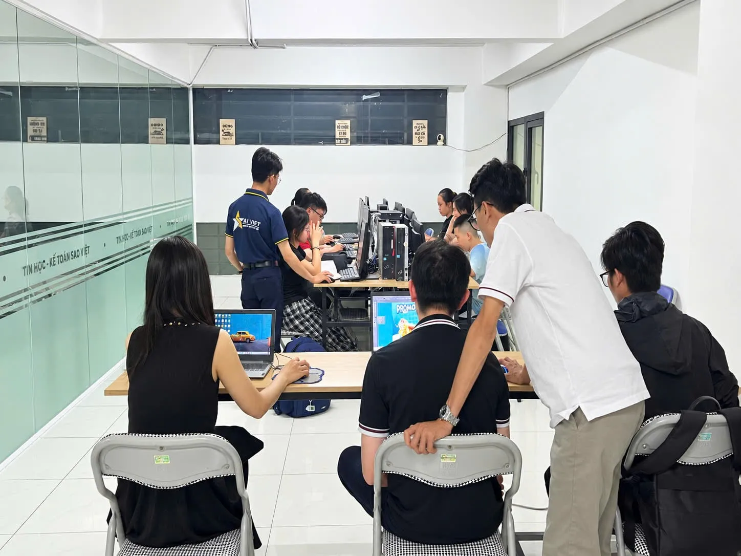 Hai giảng viên hỗ trợ lớp học máy tính